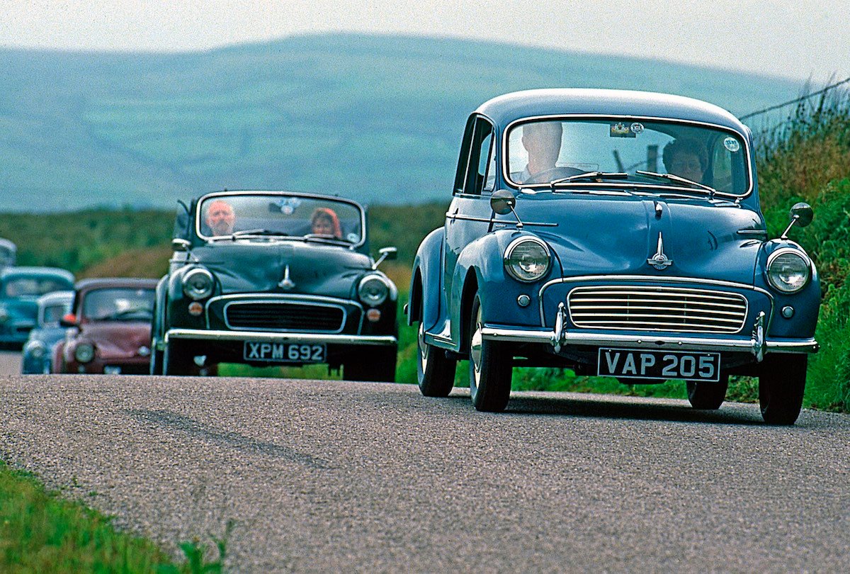 Several Morris Minor cars driving down road